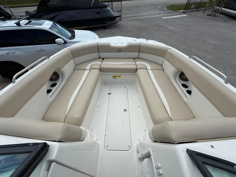 Slide: The Image of 2018 NauticStar 243DC Sport Deck boat with spacious beige seating area. - 23