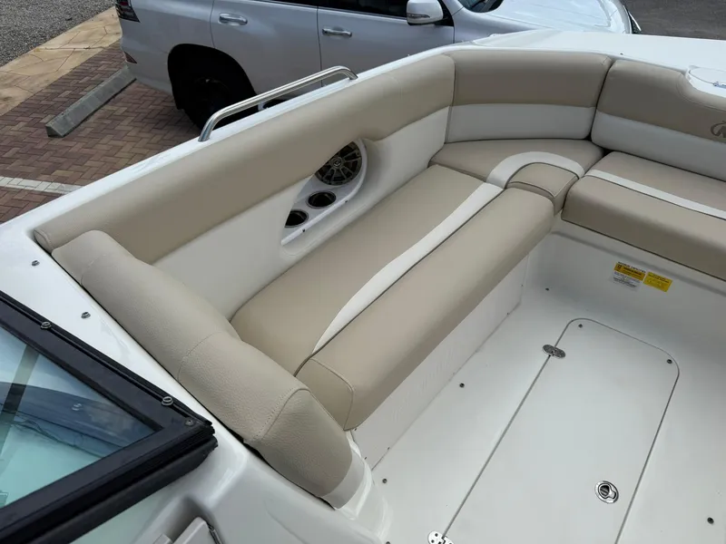 Slide: The Image of 2018 NauticStar 243DC Sport Deck boat interior with beige seating and cup holders. - 24