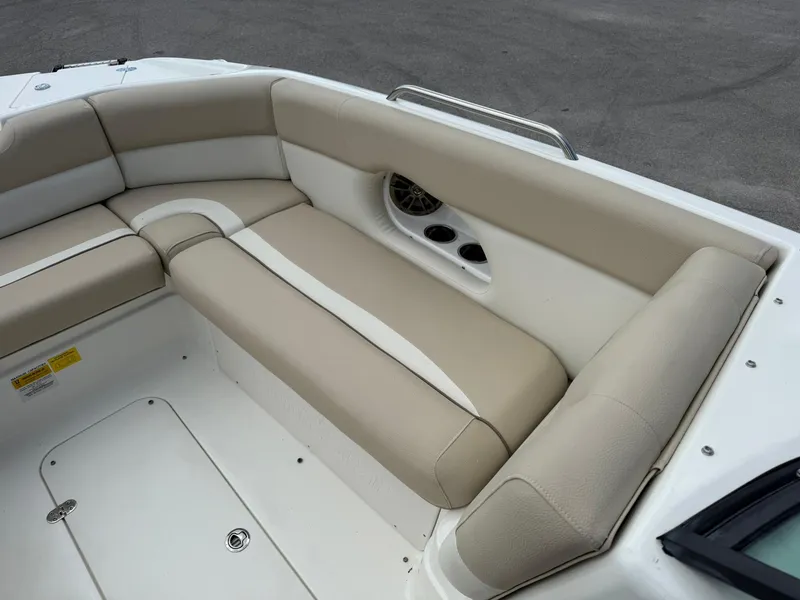 Slide: The Image of 2018 NauticStar 243DC Sport Deck boat interior with beige seating and cup holders. - 25