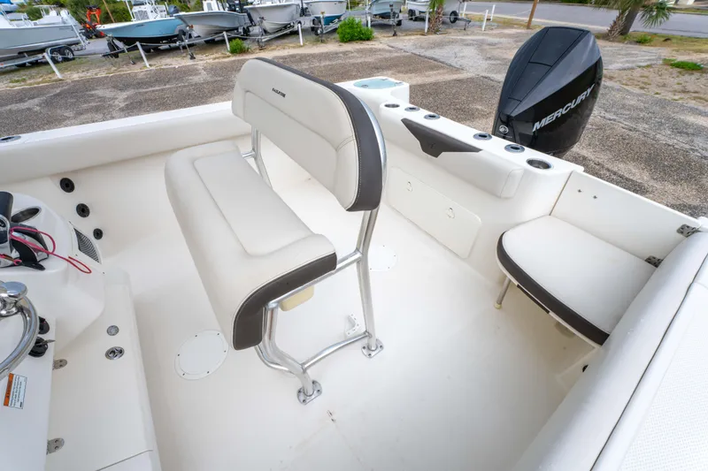 Slide: The Image of 2022 Sailfish 242CC boat with outboard motor and ladder, parked on a sunny day. - 12