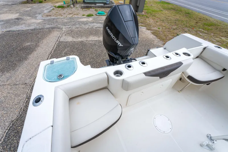 Slide: The Image of 2022 Sailfish 242CC boat with Mercury outboard motor and ladder, parked outdoors. - 14