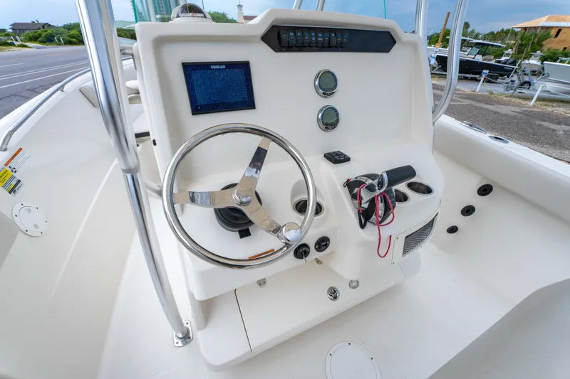 Slide: The Image of 2022 Sailfish 242CC boat interior with steering wheel and seating area. - 19