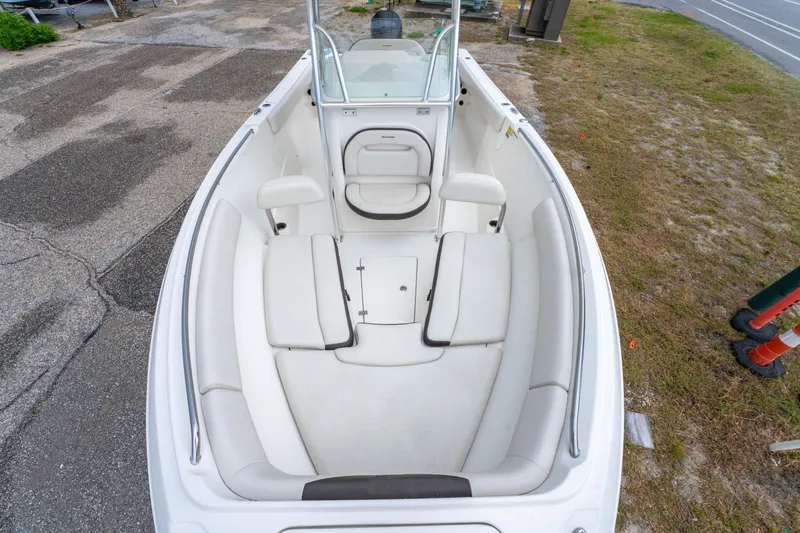 Slide: The Image of 2022 Sailfish 242CC boat interior with seating and control panel, near coastal road. - 25