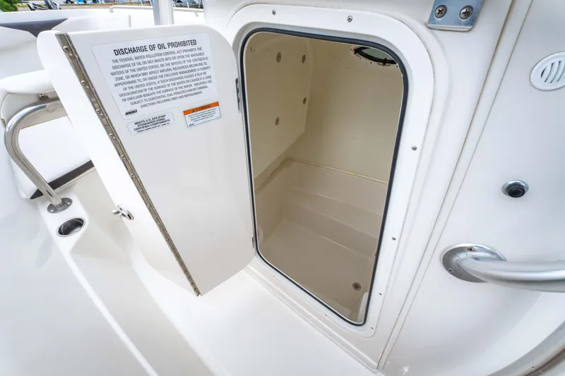 Slide: The Image of 2022 Sailfish 242CC boat interior with helm, seating, and console in a sunny outdoor setting. - 26