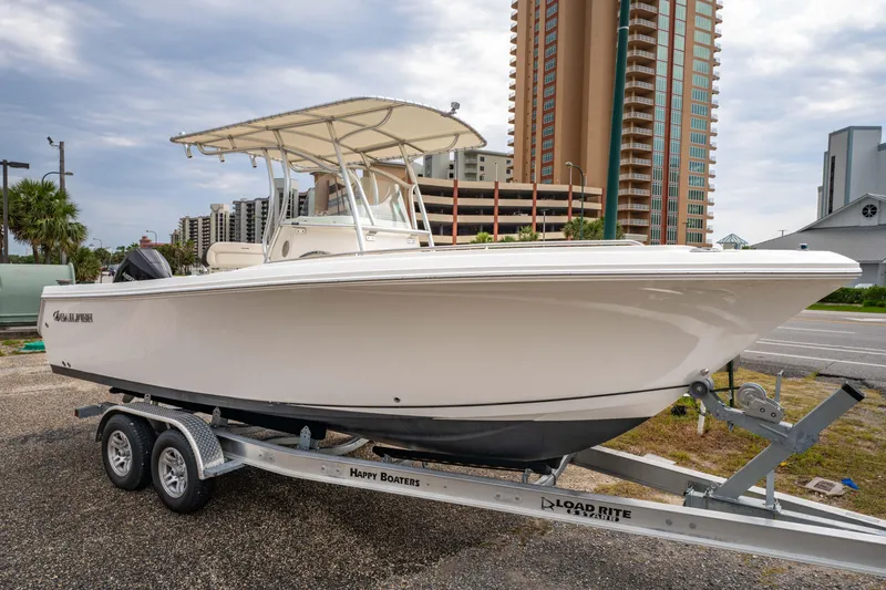 Slide: The Image of 2022 Sailfish 242CC boat on trailer with Mercury outboard engine, parked outdoors. - 3