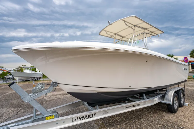Slide: The Image of 2022 Sailfish 242CC boat on trailer under clear blue sky. - 4