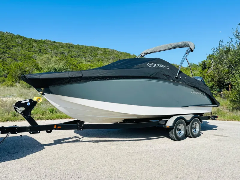 Slide: The Image of 2018 Cobalt 23SC boat on trailer, covered, parked outdoors. - 10
