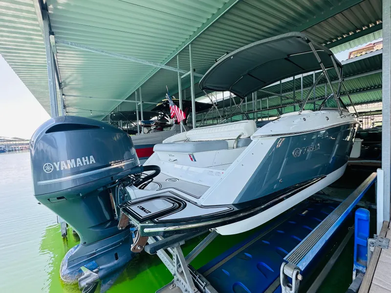 Slide: The Image of 2018 Cobalt 23SC boat with Yamaha engine docked under a covered marina. - 17