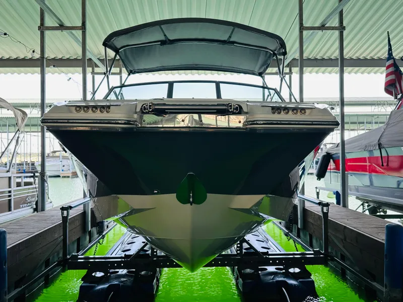 Slide: The Image of 2018 Cobalt 23SC boat docked in a covered marina, front view. - 20
