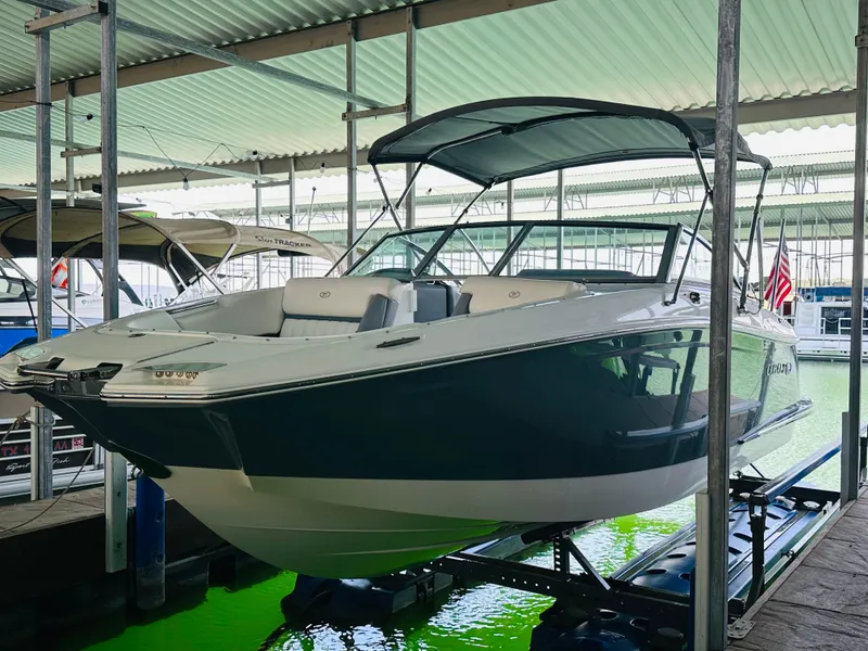 Slide: The Image of 2018 Cobalt 23SC boat docked in a covered marina with green water below. - 21