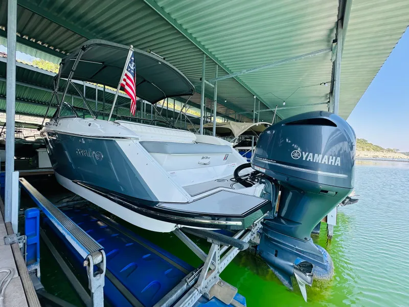 Slide: The Image of 2018 Cobalt 23SC boat with Yamaha engine docked under a covered marina. - 22