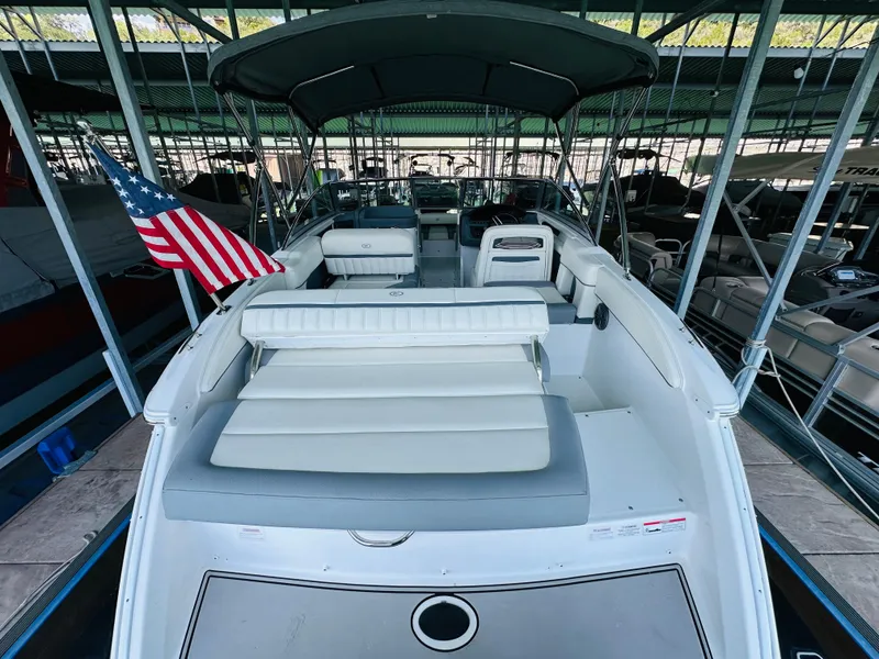 Slide: The Image of 2018 Cobalt 23SC boat with American flag, docked under a canopy. - 27