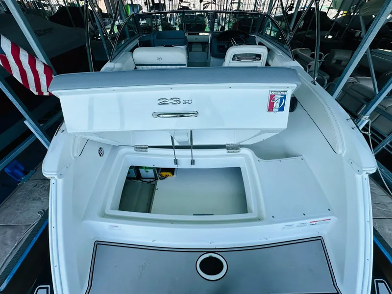 Slide: The Image of 2018 Cobalt 23SC boat interior with open storage compartment, docked in a marina. - 28