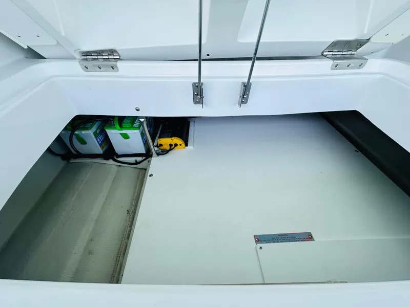 Slide: The Image of Open storage compartment in a 2018 Cobalt 23SC boat, showing interior details and equipment. - 29
