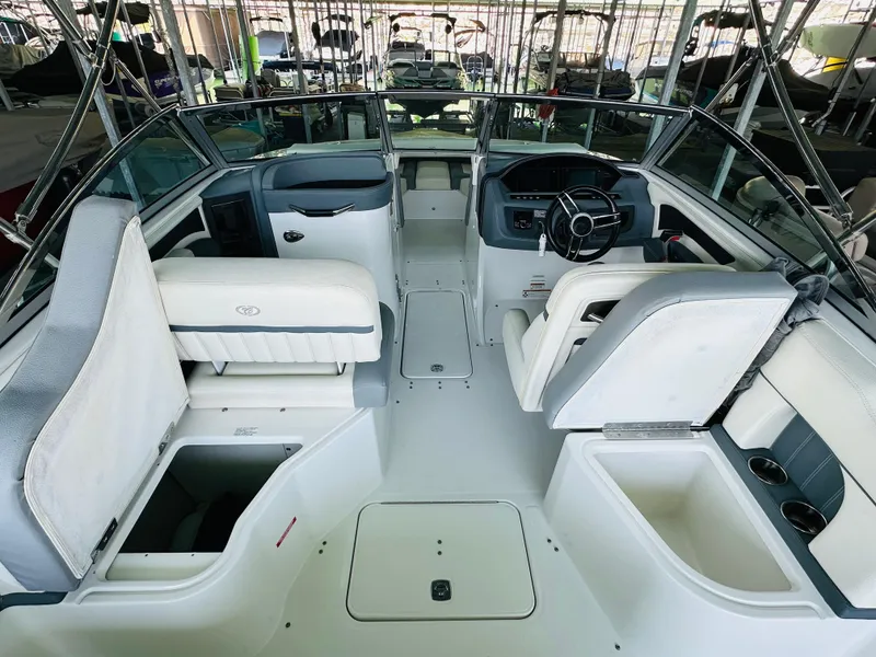 Slide: The Image of 2018 Cobalt 23SC boat interior with seating, steering wheel, and storage compartments. - 33