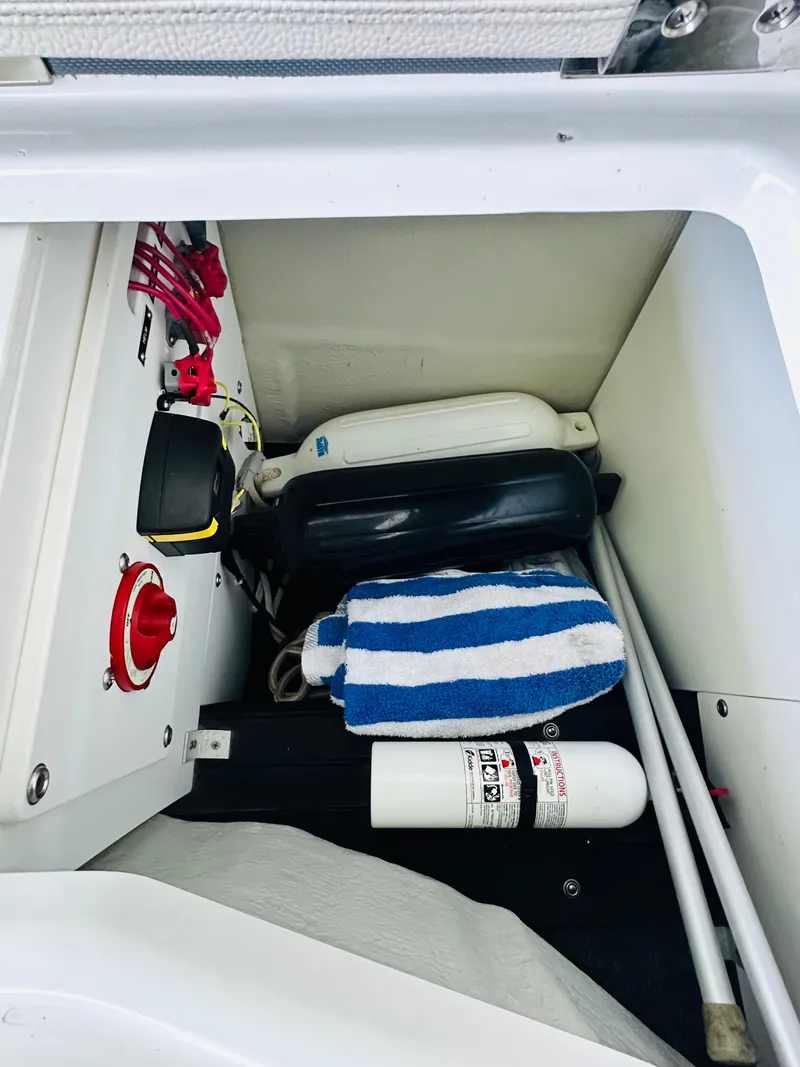 Slide: The Image of Storage compartment of a 2018 Cobalt 23SC boat with safety equipment and accessories. - 35
