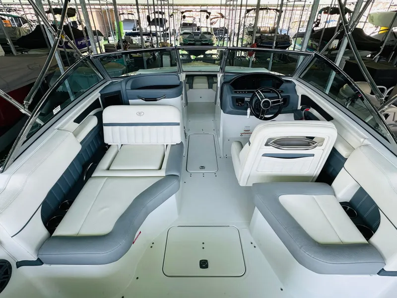 Slide: The Image of 2018 Cobalt 23SC boat interior with white and gray seating, steering wheel, and dashboard. - 36