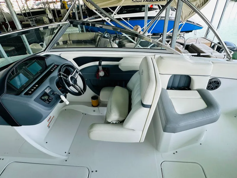 Slide: The Image of 2018 Cobalt 23SC boat interior with steering wheel and seating area. - 37