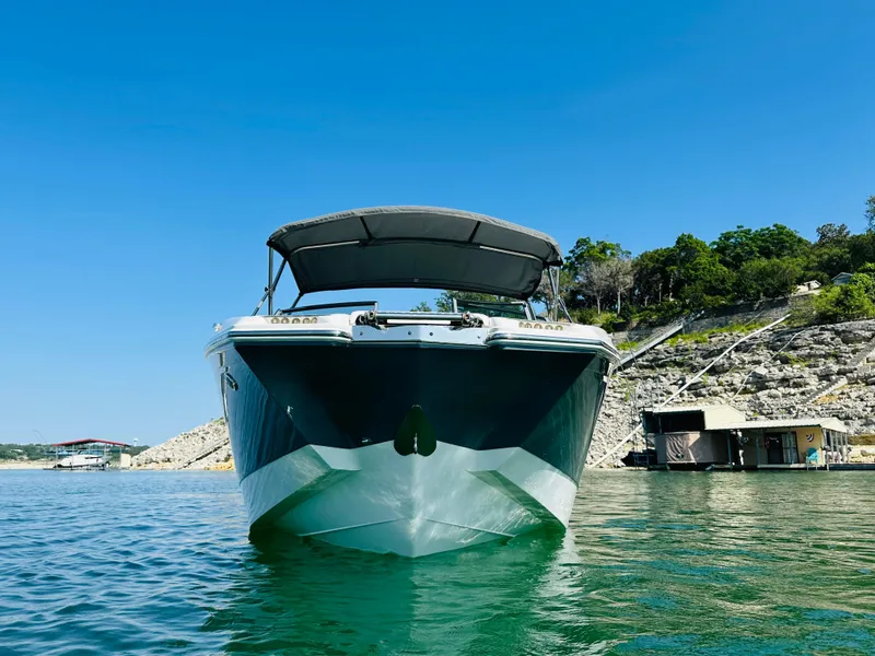 Slide: The Image of 2018 Cobalt 23SC boat on clear water with rocky shoreline and blue sky. - 4