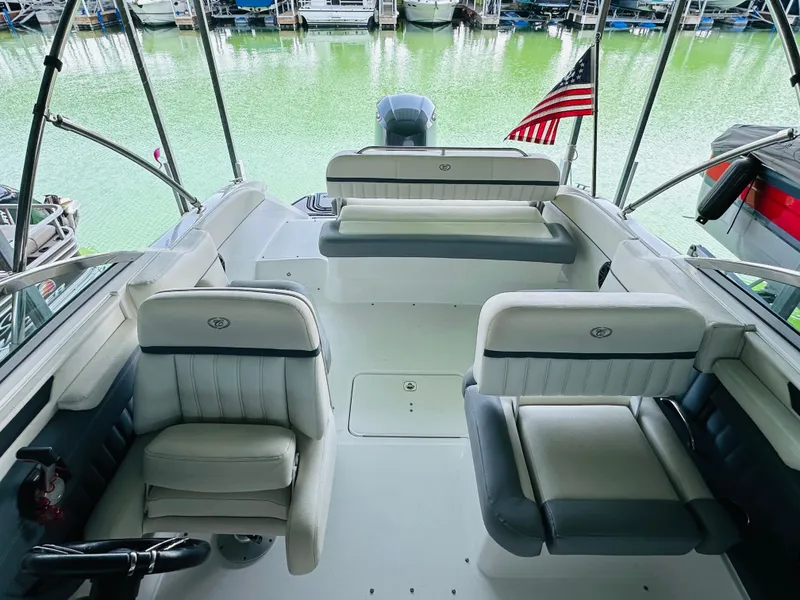 Slide: The Image of 2018 Cobalt 23SC boat interior with seating, docked on green water. - 40