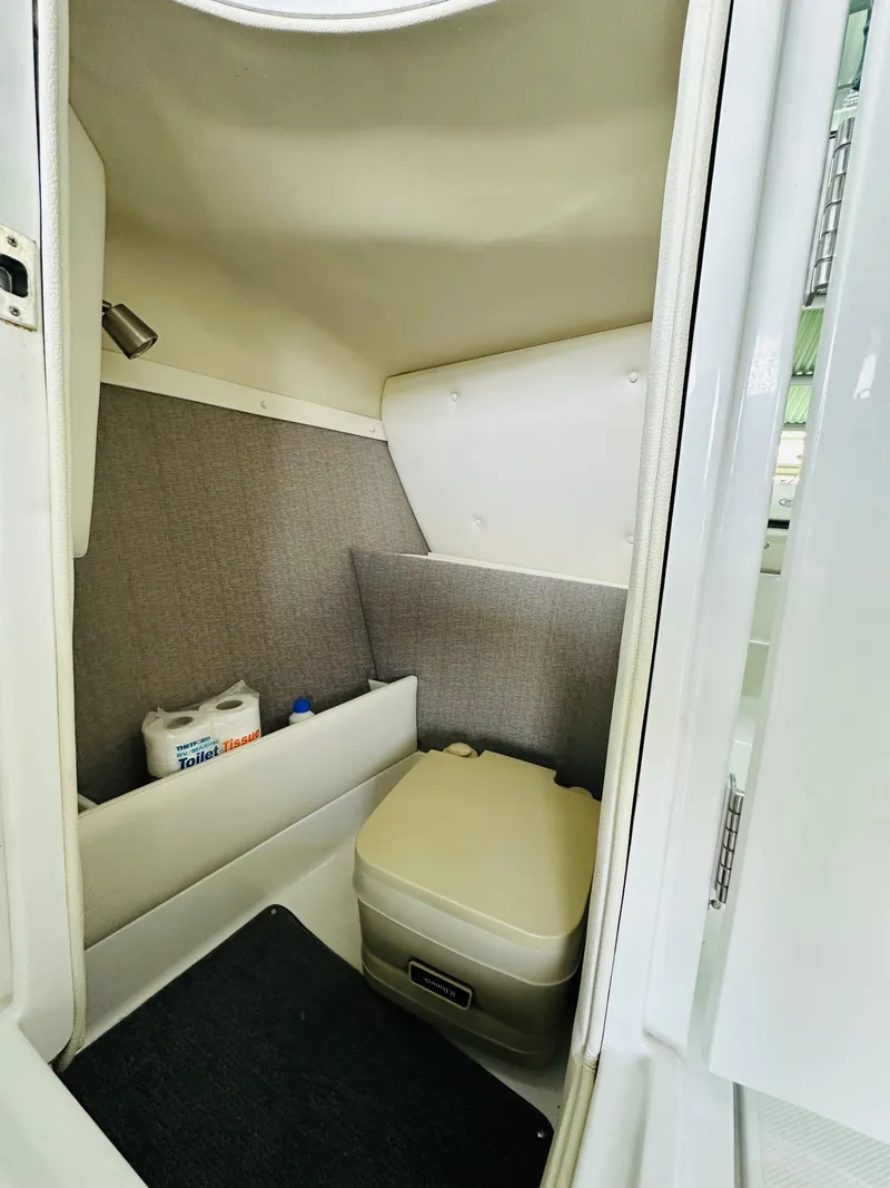 Slide: The Image of 2018 Cobalt 23SC boat interior with compact toilet and storage area. - 42