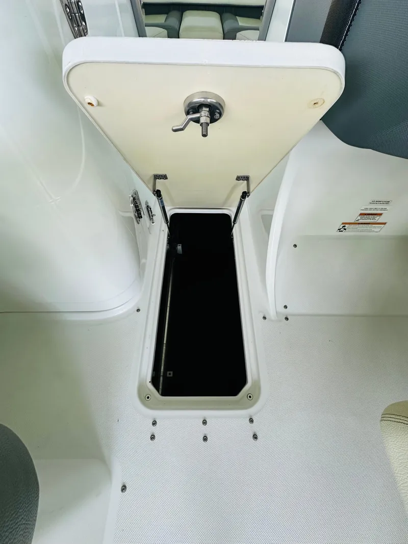Slide: The Image of 2018 Cobalt 23SC boat storage compartment with open hatch and latch. - 45
