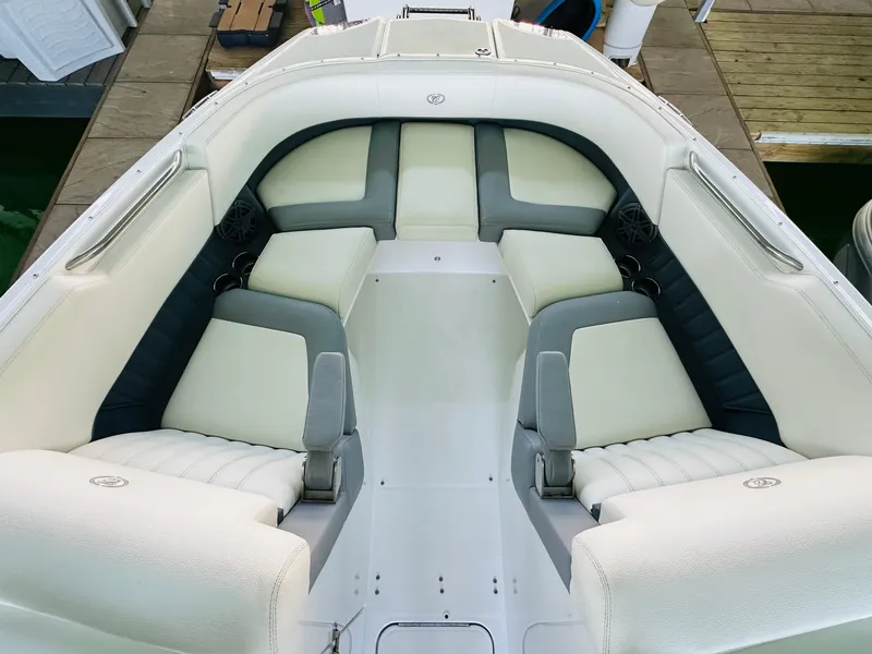 Slide: The Image of 2018 Cobalt 23SC boat interior with white and gray seating, docked at marina. - 47