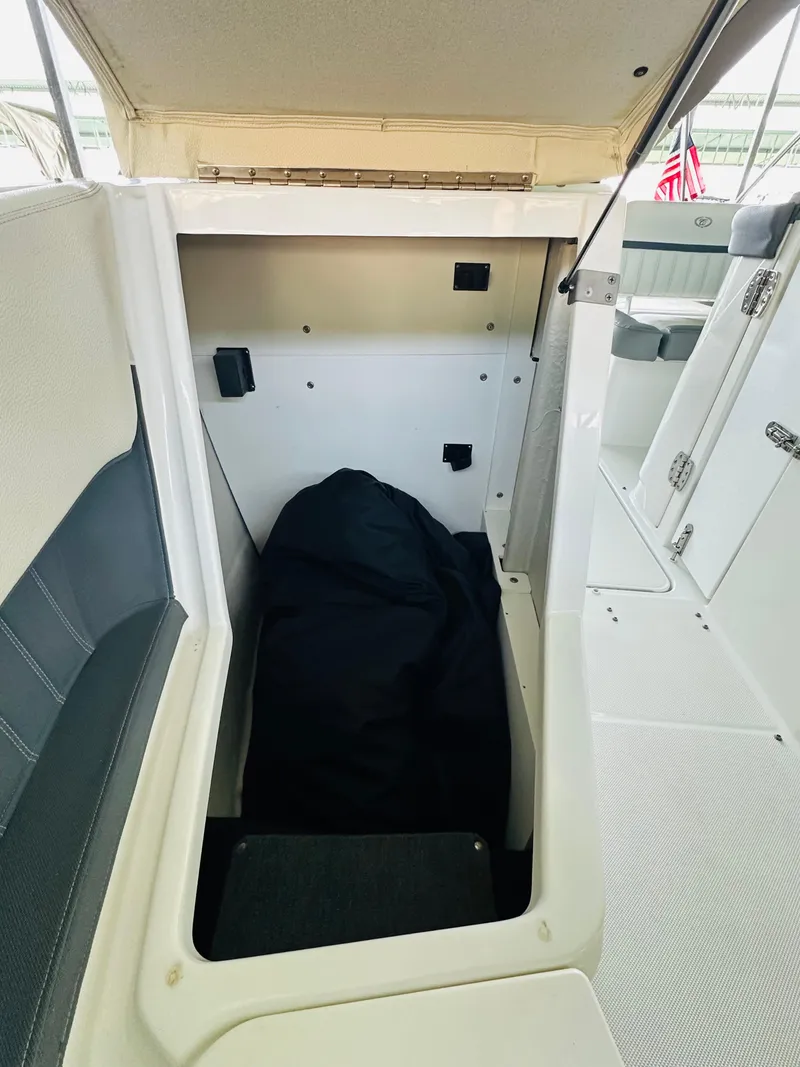 Slide: The Image of 2018 Cobalt 23SC boat interior storage compartment with open hatch. - 48