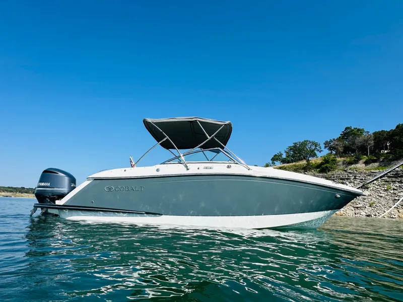 Slide: The Image of 2018 Cobalt 23SC boat on water, clear sky, shoreline in background. - 5