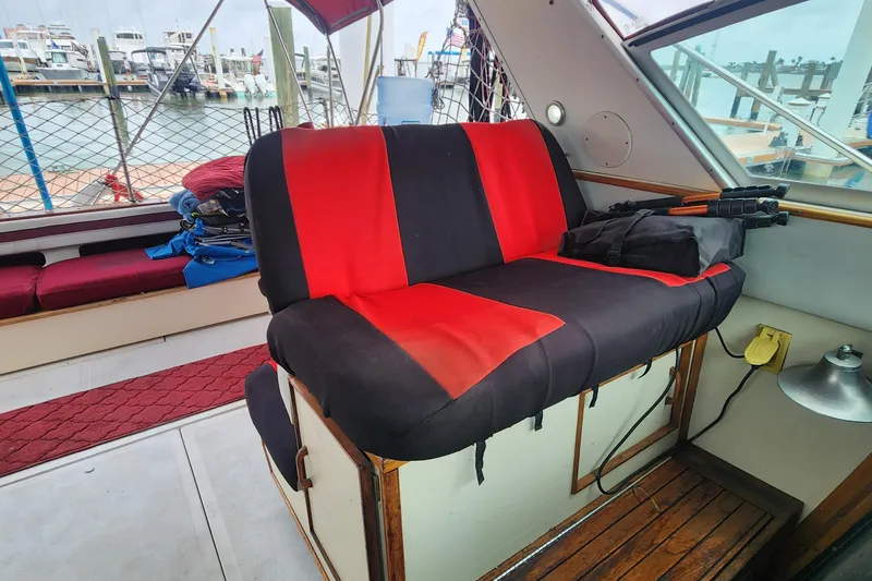 Slide: The Image of 1987 Sea Ray 390 Express Cruiser interior with red and black seating, dock view. - 10