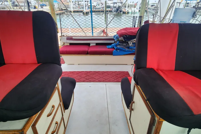 Slide: The Image of 1987 Sea Ray 390 Express Cruiser interior with red and black seating, dock view. - 11