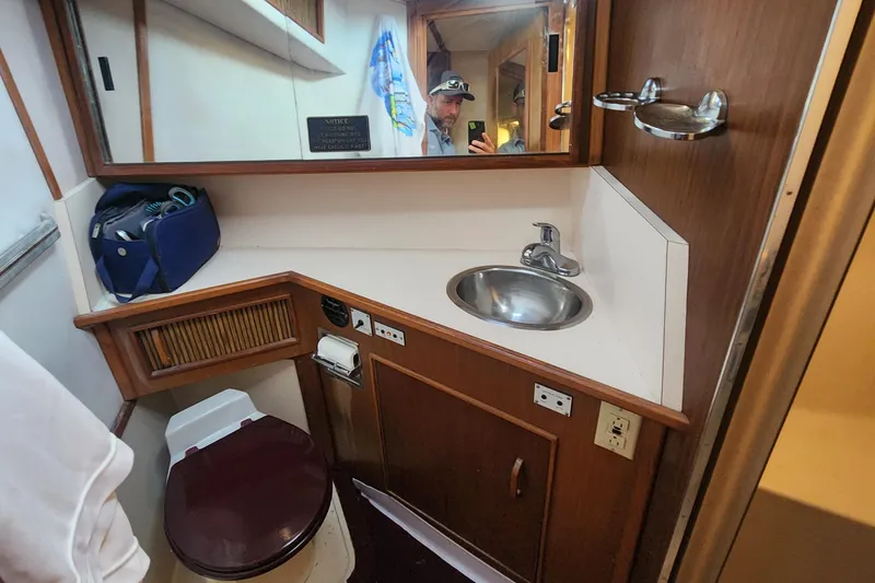 Slide: The Image of 1987 Sea Ray 390 Express Cruiser bathroom with sink, mirror, and toilet. - 12