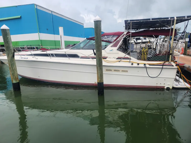 Slide: The Image of 1987 Sea Ray 390 Express Cruiser docked at marina, side view. - 2