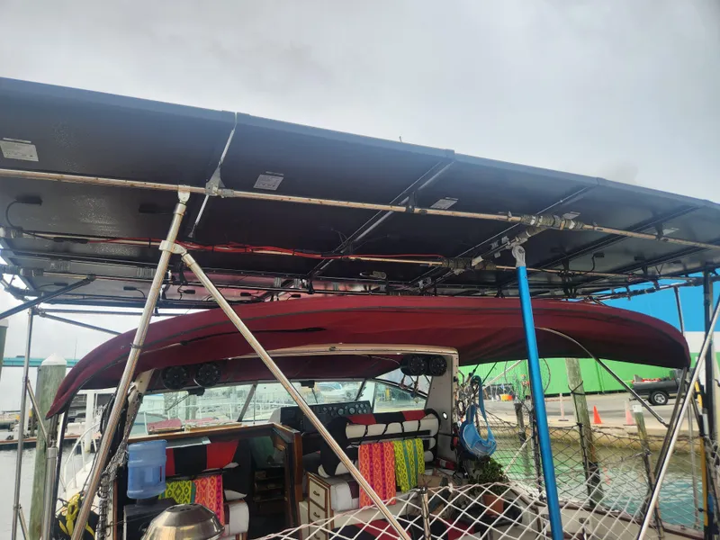Slide: The Image of 1987 Sea Ray 390 Express Cruiser with solar panels and colorful interior at a marina. - 4