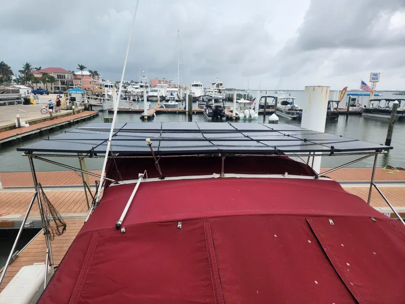 Slide: The Image of 1987 Sea Ray 390 Express Cruiser docked at marina with solar panels and red canopy. - 7