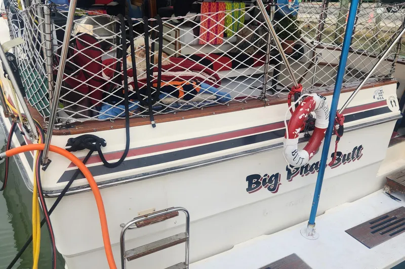 Slide: The Image of 1987 Sea Ray 390 Express Cruiser docked with safety netting and lifebuoy. - 8