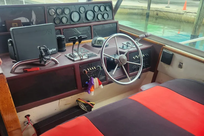Slide: The Image of 1987 Sea Ray 390 Express Cruiser helm with steering wheel and control panel. - 9