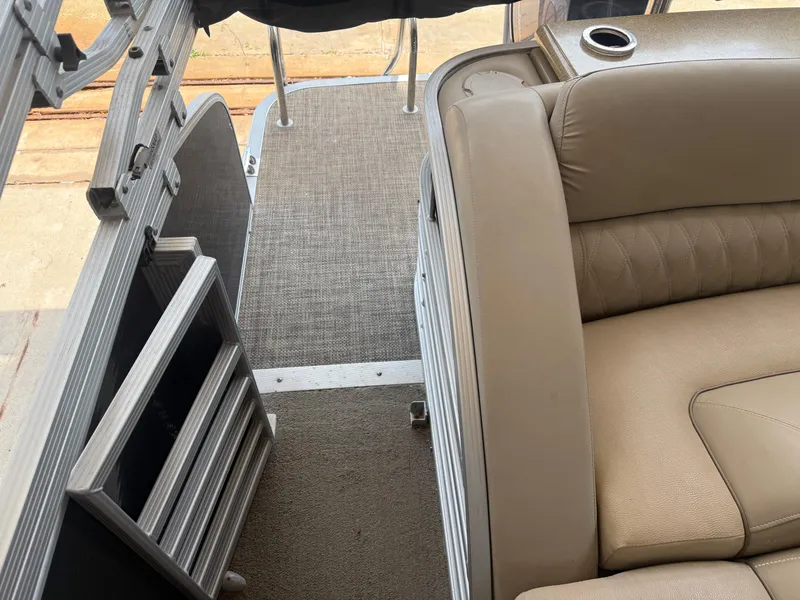 Slide: The Image of 2014 Bennington 2550 RCB boat interior with beige seating and cup holder. - 17