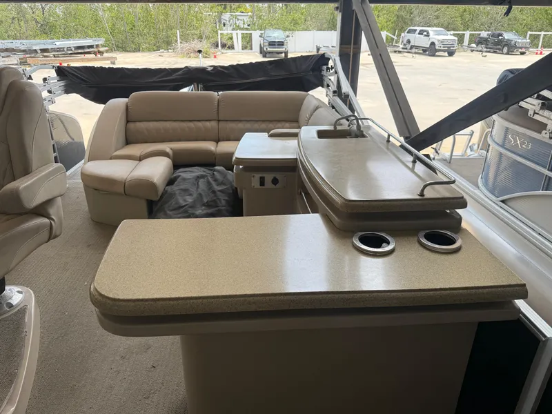 Slide: The Image of 2014 Bennington 2550 RCB boat interior with beige seating and countertop. - 20