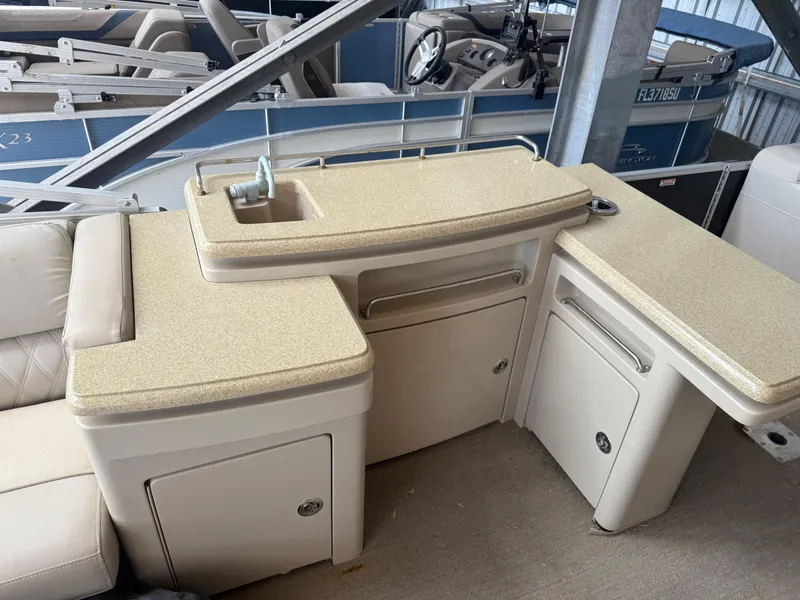 Slide: The Image of 2014 Bennington 2550 RCB boat interior with beige countertops and storage compartments. - 21