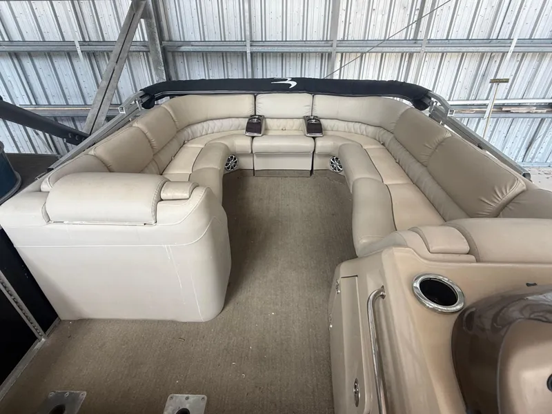 Slide: The Image of 2014 Bennington 2550 RCB boat interior with beige seating and cup holders. - 23
