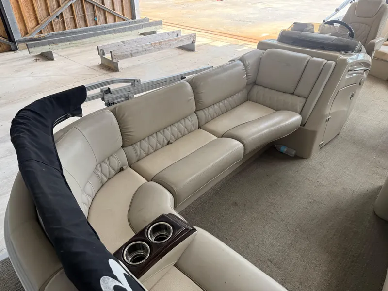 Slide: The Image of 2014 Bennington 2550 RCB boat interior with beige seating and cup holders. - 24