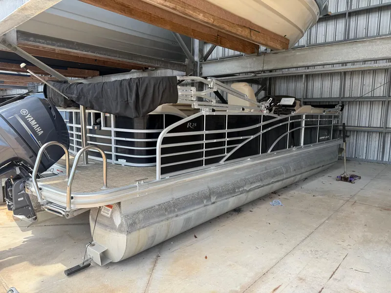 Slide: The Image of 2014 Bennington 2550 RCB pontoon boat in storage, featuring Yamaha outboard motor. - 3