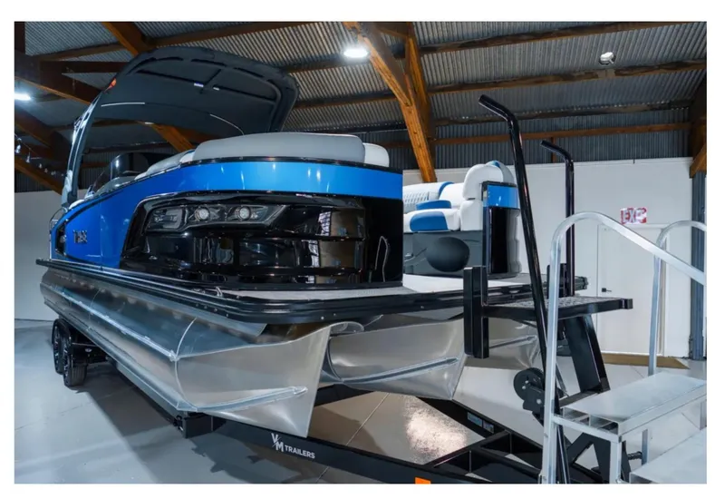 Slide: The Image of 2025 Tahoe Grand Tahoe LTD pontoon boat in showroom, featuring sleek blue design. - 7