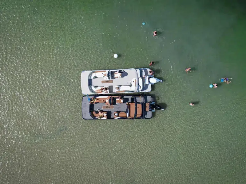 Slide: The Image of Aerial view of two boats on clear water with people swimming nearby. - 21