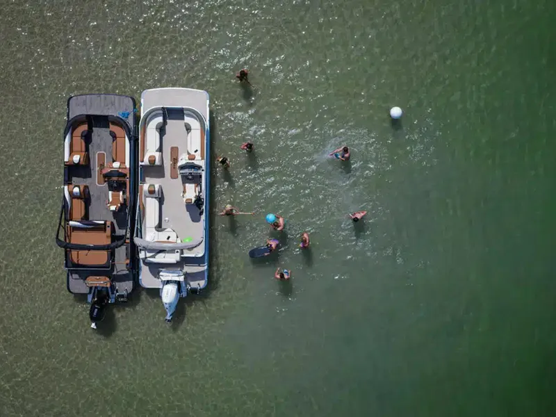 Slide: The Image of Aerial view of two boats and people swimming in clear green water. - 23