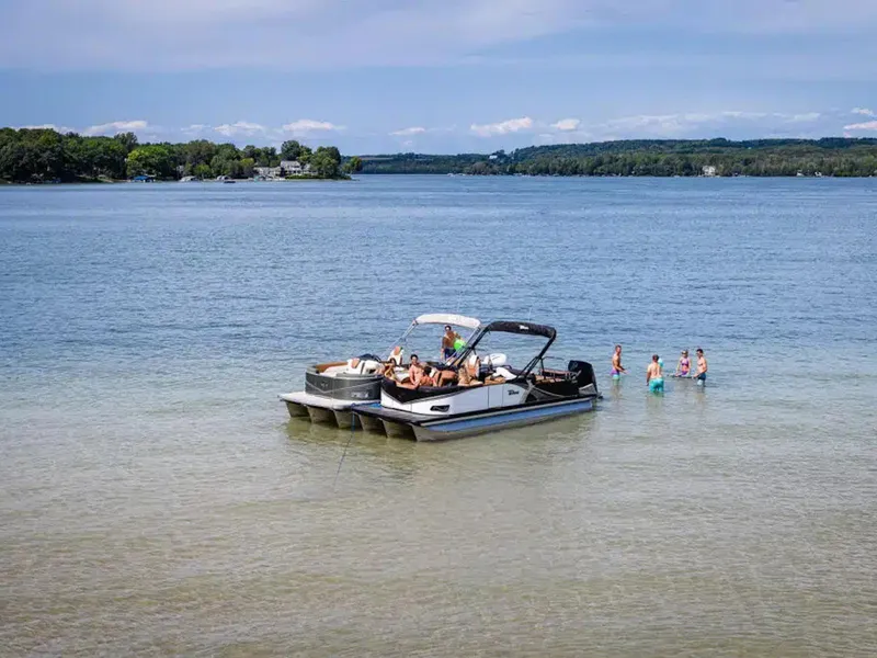 Slide: The Image of People enjoying a day on a Tahoe LTZ 2025 pontoon boat in a scenic lake. - 25