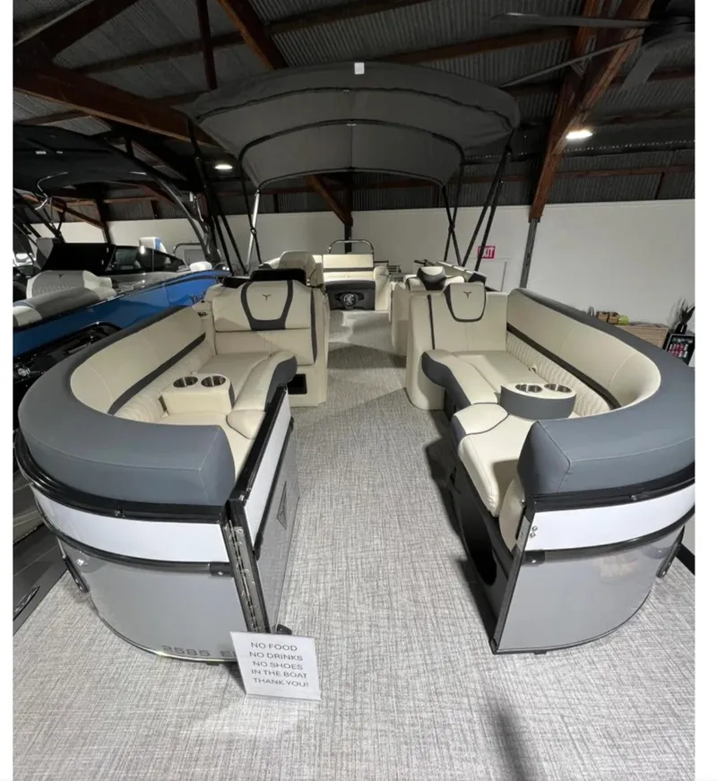 Slide: The Image of 2025 Tahoe CASCADE pontoon boat interior with plush seating and canopy in showroom. - 3