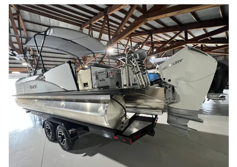 Slide: The Image of 2025 Tahoe CASCADE pontoon boat with Mercury engine in a wooden-roofed storage facility. - 5