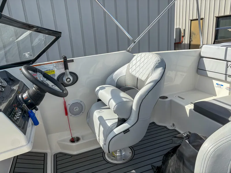 Slide: The Image of 2021 Bayliner VR4 boat interior with steering wheel and cushioned captain's chair. - 11